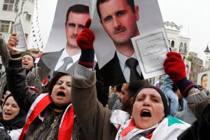 Supporters of Syria's President Bashar al-Assad hold up a copy of the new constitution during a rally in Damascus